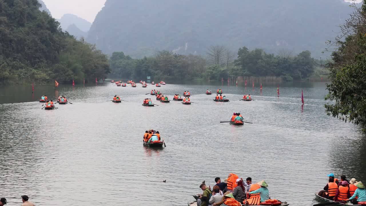 구명조끼 를 입은 관광객 들 이 보트 투어 를 즐기고 있다