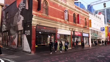 pedestrians walking past buildings in melbourne