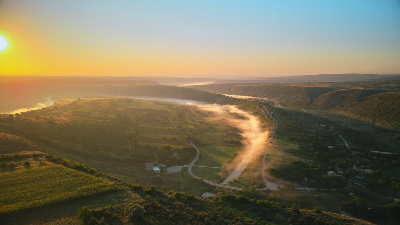 Aerial drone view of the Old Orhei at sunset. Valley with river and fog, village, monastery located on a hill in Moldova