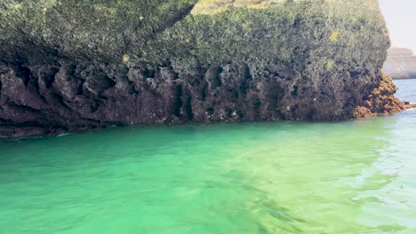 pov entering benagil cave, portugal, by boat, waves lapping sand, turning to exit right
