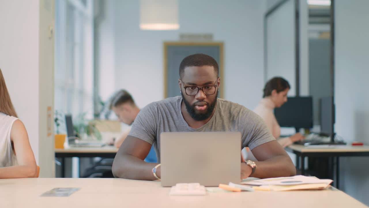 Happy afro man enjoy good results on laptop computer in office. Shocked man