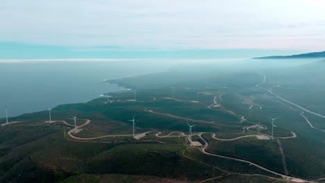 Dolly-in-aerial-view-of-several-wind-turbines-of-a-wind-farm-in-the-desert-mountains-near-the-sea-of-northern-Chile