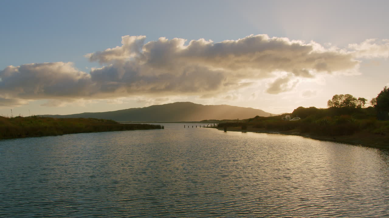 Sunset over a Calm Lake with Mountains in the Background