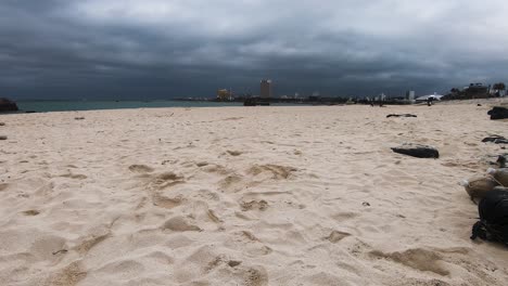 low angle time lapse of sand on araha beach, chatan, okinawa, japan on a cloudy day