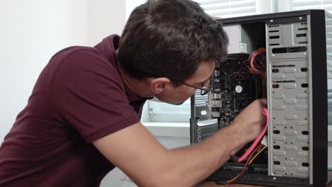 Closeup-view-of-a-concentrated-computer-service-worker-in-glasses-fixing-a-broken-computer-in-the-office-and-upgrading-computer-hardware.-Support-team.-Computer-maintenance.-Shot-in-4k