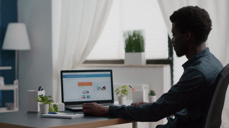 African american manager working from home, analysing graphs with sales and income