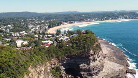 vista panorámica del paisaje de tiro aéreo de drones de winnie bay avoca promontorio con cueva y matorrales suburbio de la costa central de copacabana nsw australia 4k