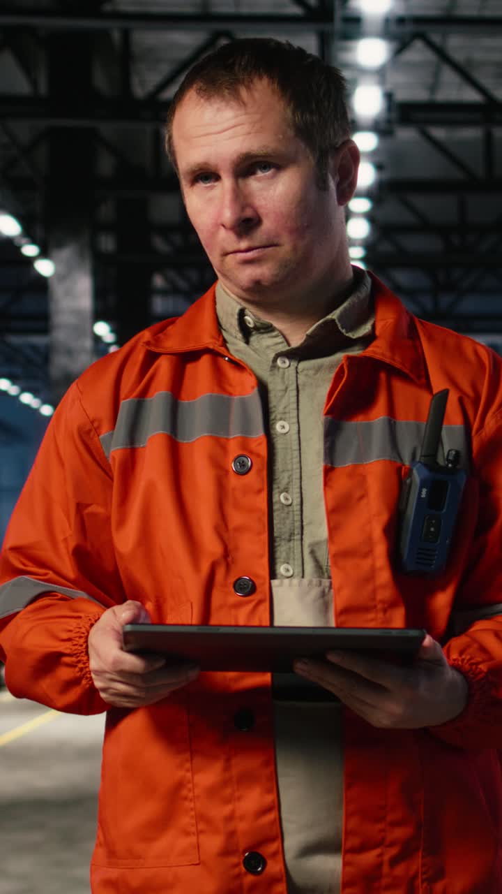 Vertical Video Supervisor in uniform inspecting steel equipment on the factory floor