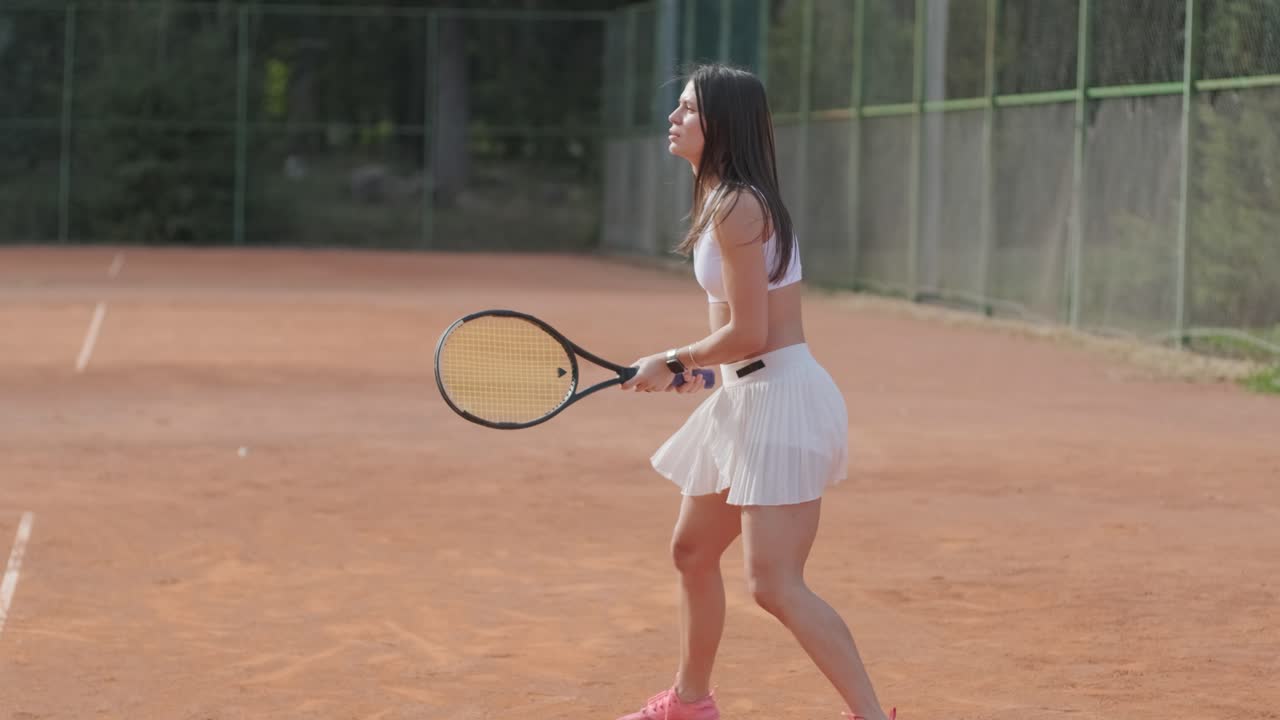 여자 테니스 선수 가 야외 코트 에서 세브 를 연습 하고 있다