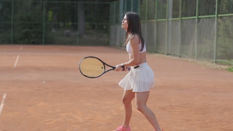 jugadora de tenis practicando el servicio en la cancha al aire libre