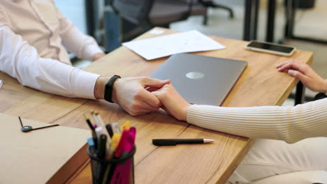 las manos de los compañeros de trabajo en la oficina