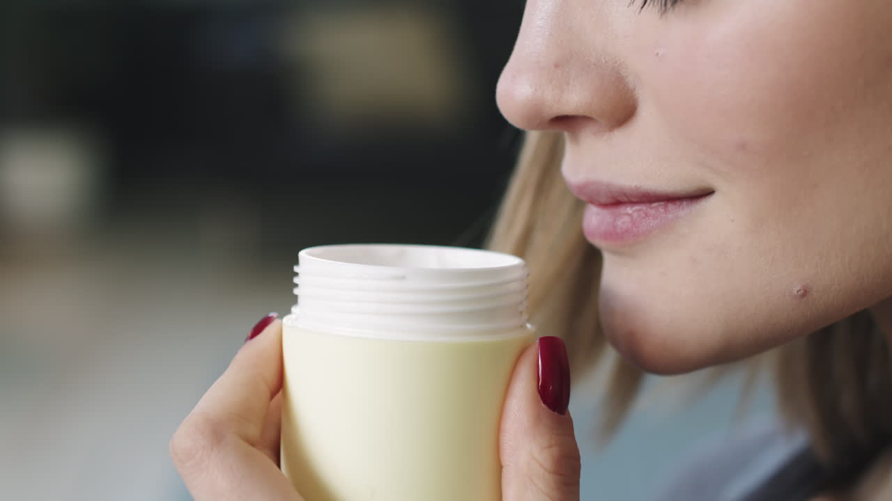 Beautiful Young Woman Smelling Cream