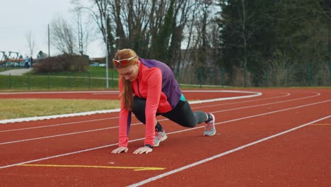 stunning 4k video of a young female athlete warming up on a running track. filmed during the sunny spring day.