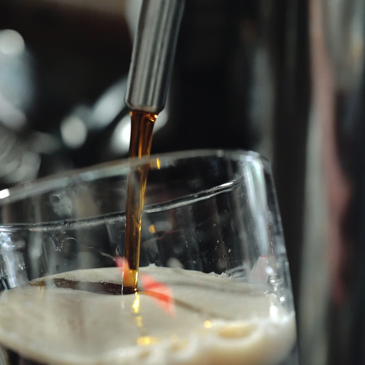 Bartender pours a dark beer in glass. Close-up. Sqare video