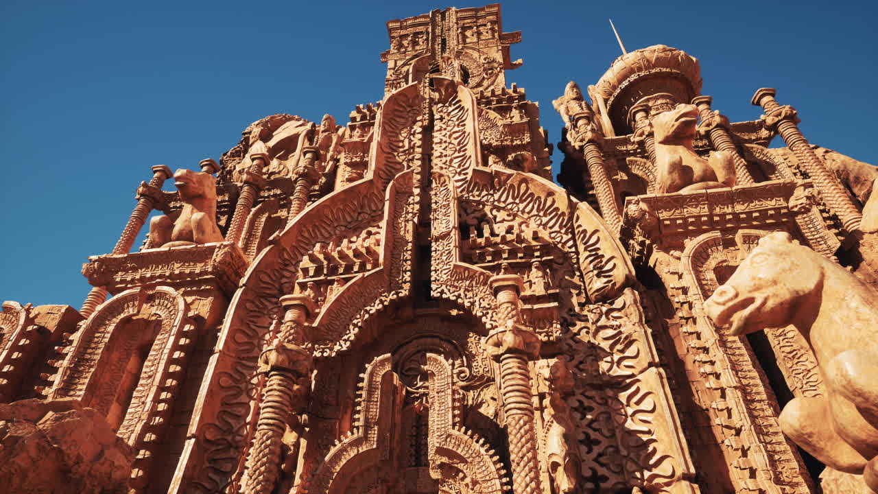 A magnificent, intricate stone castle with ornate details and carvings, standing against a bright blue sky
