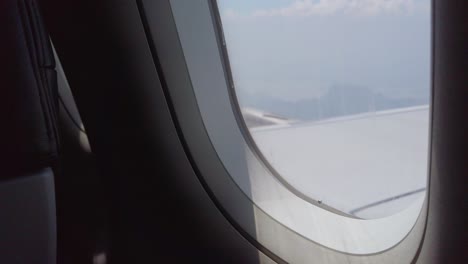 view of the plane wing through the airplane window