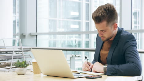 Ein-Hübscher-Junger-Geschäftsmann,-Der-An-Seinem-Laptop-Arbeitet