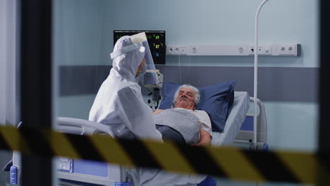 medical personnel in ppe caring for an elderly patient in a hospital isolation ward