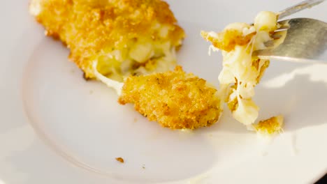 Cutlery Being Used to Cut and Pick Up Crispy Mac and Cheese Croquette on White Plate. Slow Motion Food Clip
