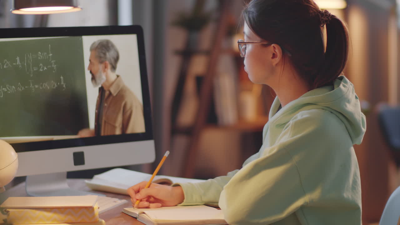 una adolescente estudiando a través de una llamada de video en la computadora en casa