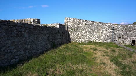 stone walls of ancient castle surrounding town square, medieval european architecture