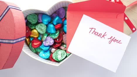 heart-shaped gift box with chocolates and thank you note
