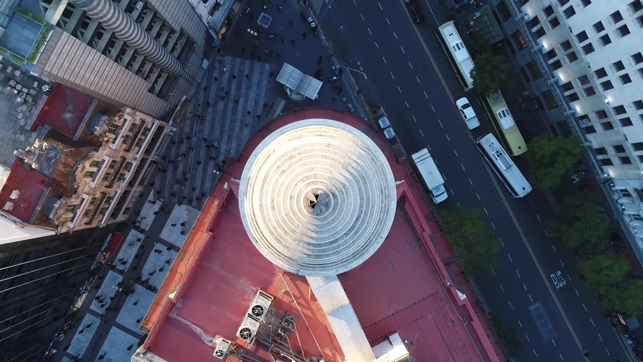 perspectiva aérea dinámica que captura el paisaje urbano, con calles bulliciosas llenas de actividad vehicular y peatones en movimiento