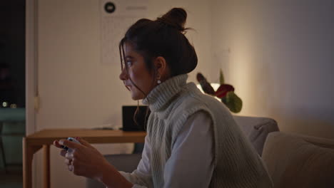 focused woman competing video game late evening closeup. girl holding joystick