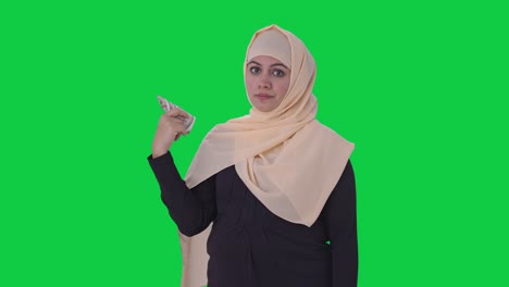 egoistic muslim woman using money as fan green screen