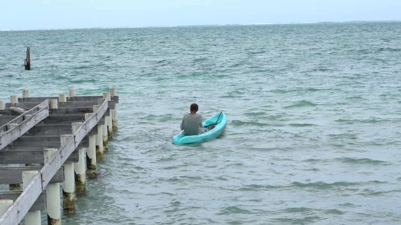 An old man on the kayak during a windy day in Belize, Caye Caulker island