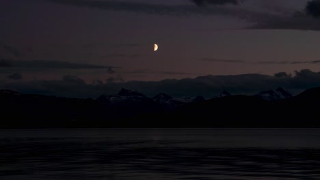 beautiful time lapse of the moon watching over sea and mountain view