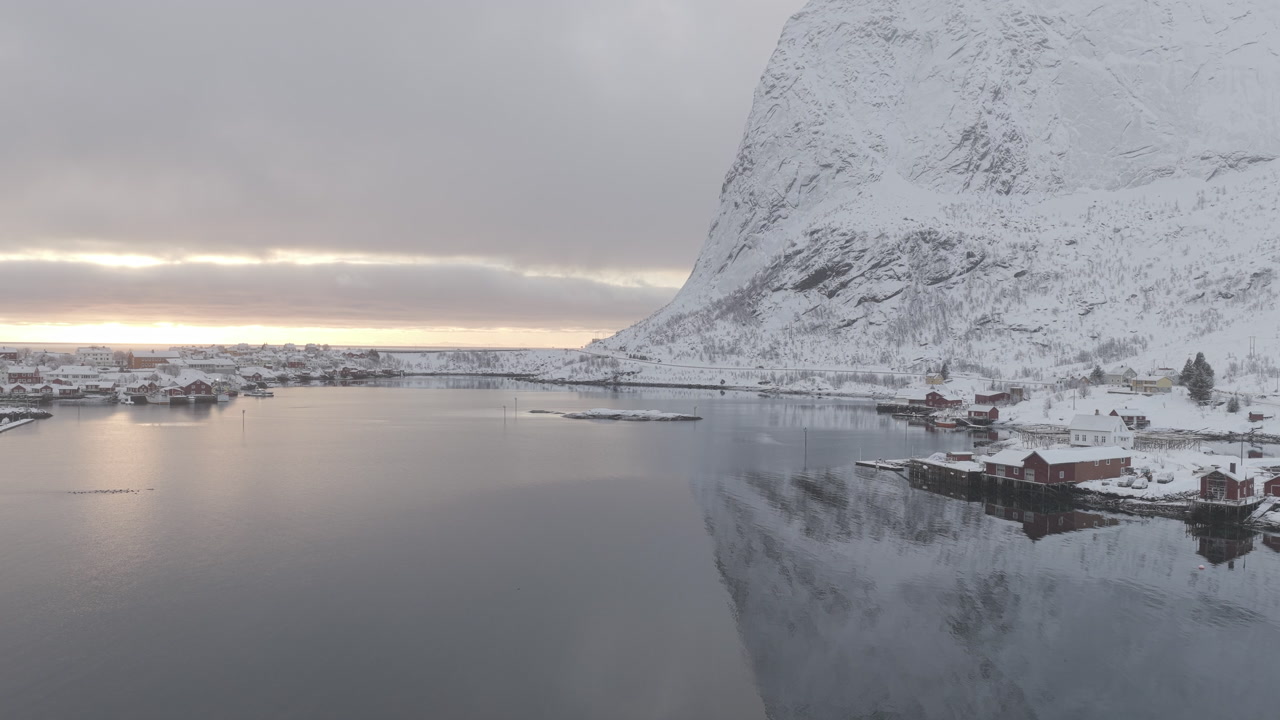 A breathtaking aerial view of the snowcovered Lofoten archipelago in Norway during a winter sunset. Perfect for travel documentaries, winter tourism, and naturethemed projects.