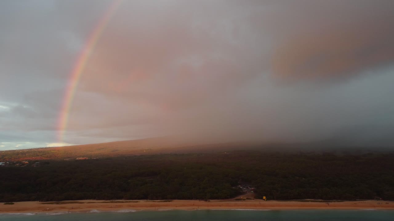 fotografía aérea lenta de un arco iris sobre la hermosa playa del sur de maui, condado de maui, hawai