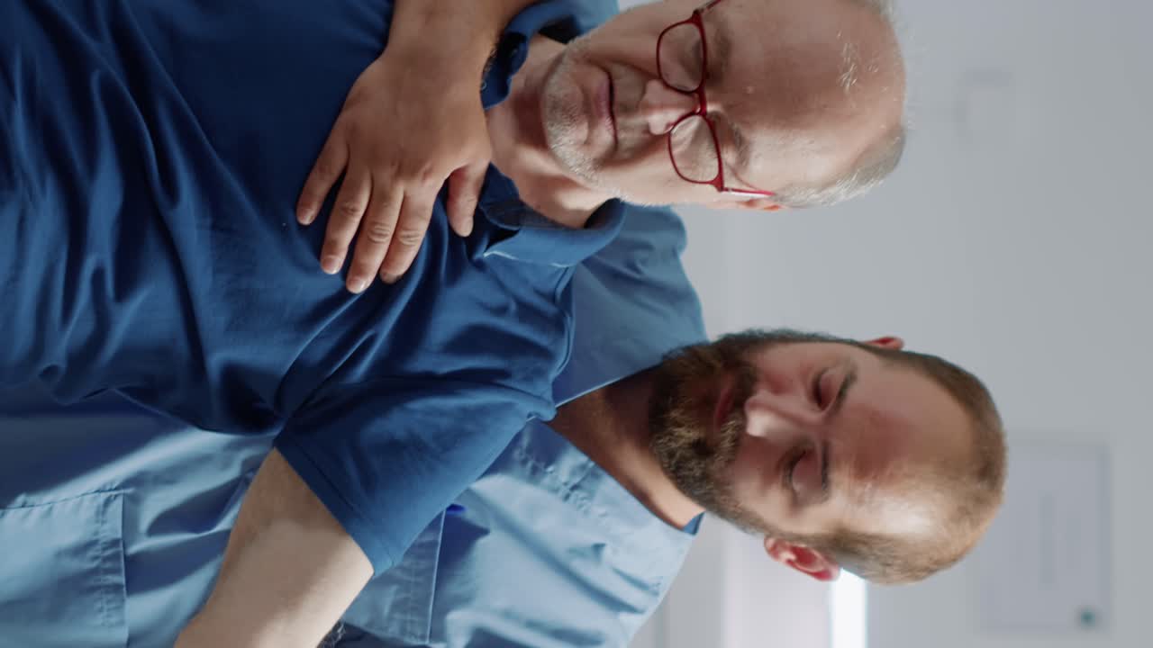 Medical assistant raising arms of elder person to stretch muscles