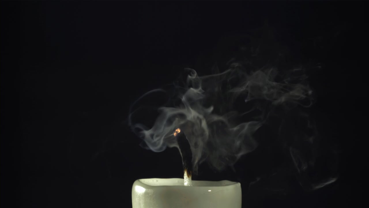 White Candle Flame Extinguishes and Smoke Rises on Black Background