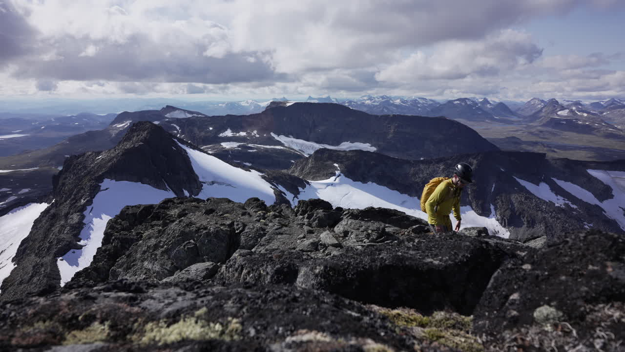 vista diagonal frontal de gran ángulo, hombre caminando en la parte superior de la montaña con vistas