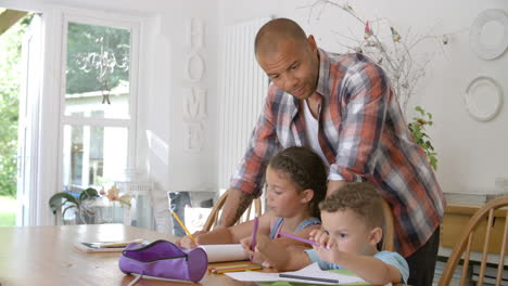 padre ayudando a los niños con la tarea en la mesa