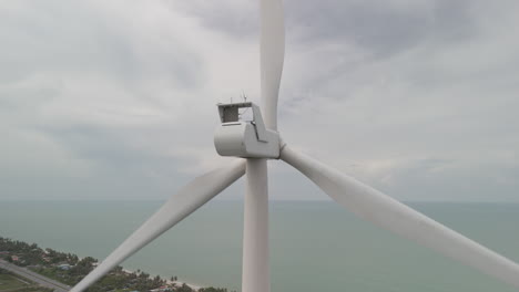 zona costera palas giratorias de la turbina eólica que crean energía eléctrica cinética renovable
