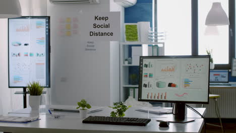 modern empty office with plastic separators and keep social distance poster