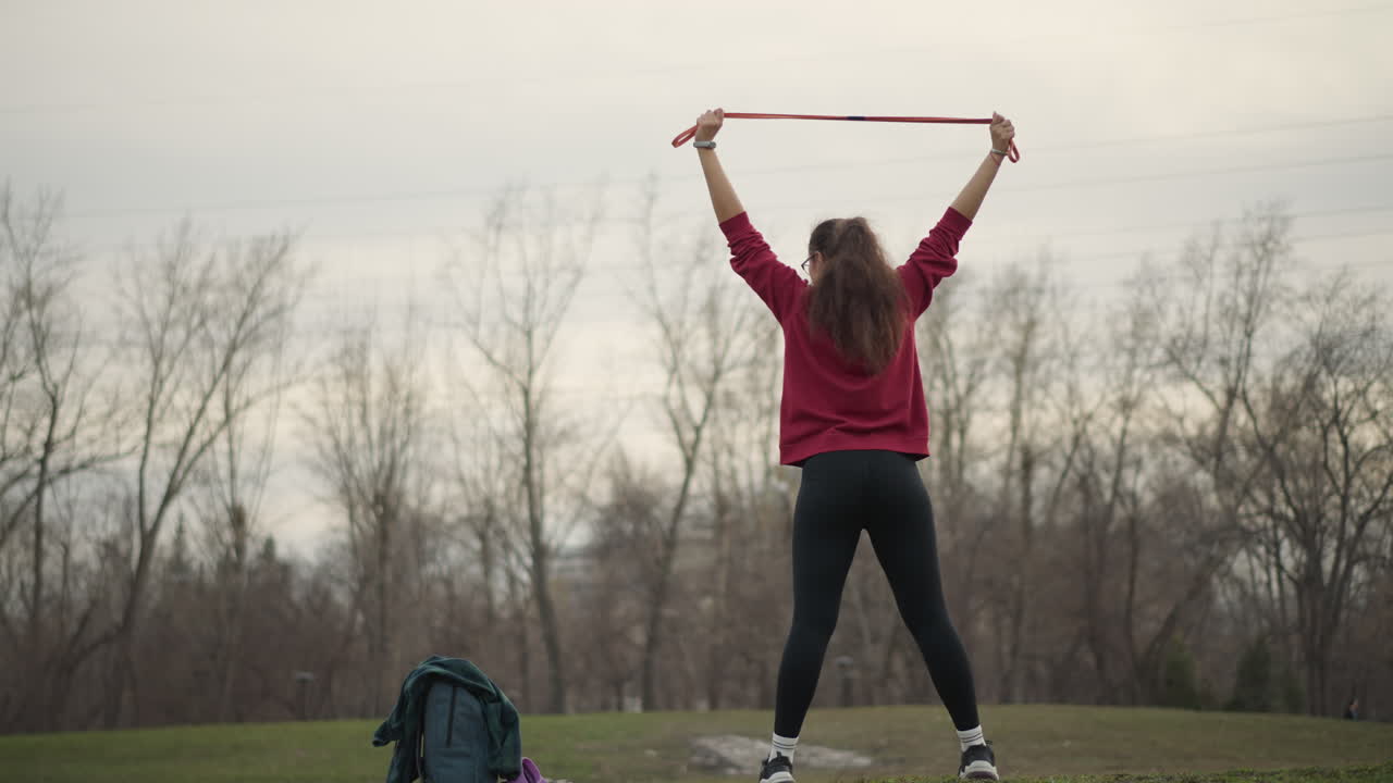 Yoga Session Held Atop Vibrant Green Hill, Woman Performs Backbend Yoga Pose On Verdant Hillside, An Outdoor Display Of Yoga Where Woman Stretches On Grassy Hilltop During Backbend Exercise