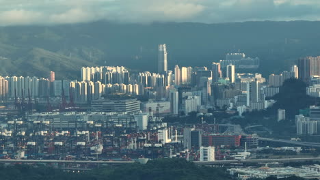 drone trucking shot of the large industrial container port with tsuen wan in the background on a cloudy day