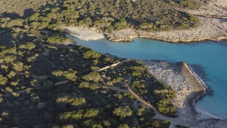 golden hour sunset along secluded white sand beach seen from the drone