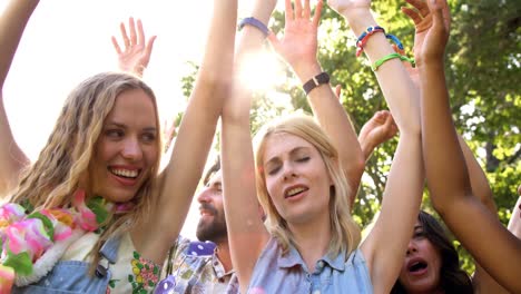 Hipster-friends-dancing-with-raised-arms