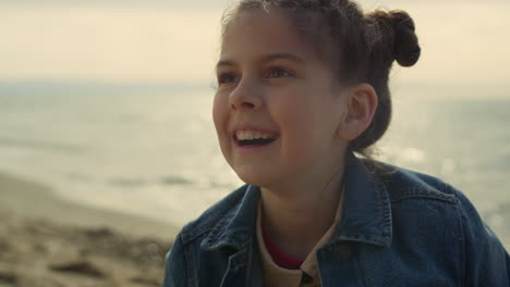 smiling girl playing beach on summer vacation. cheerful child having fun by sea.