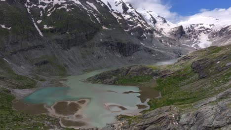 aerial view of mountain lake in alpine valley surrounded by grossglockner mountain range in austria