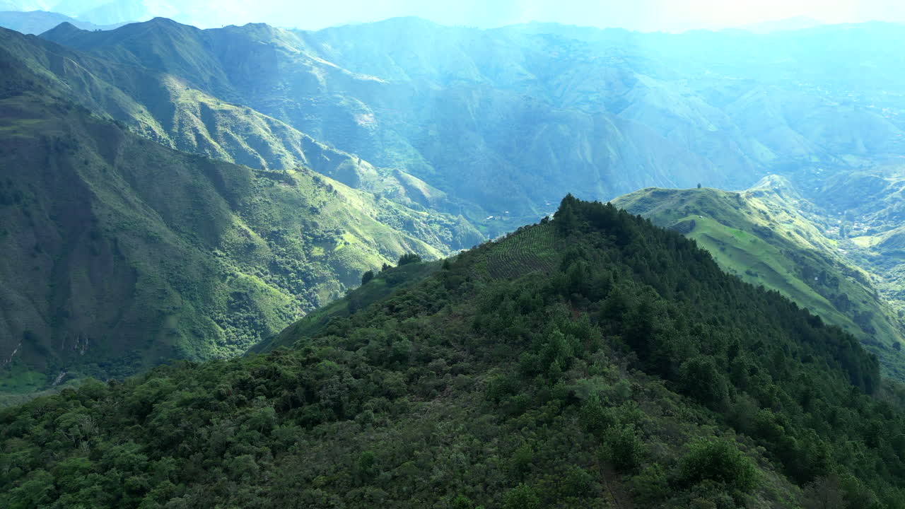 Filmato aereo cinematografico con drone che plana su creste lussureggianti ricoperte di foreste e profonde valli vicino a Vilcabamba, Ecuador, rivelando la scala mozzafiato delle Ande meridionali.