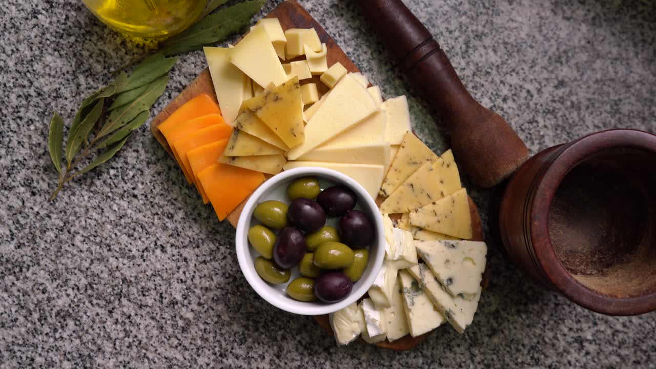 Variety of cheeses with green and black olives