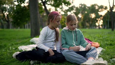 two girls studying outdoors in a park