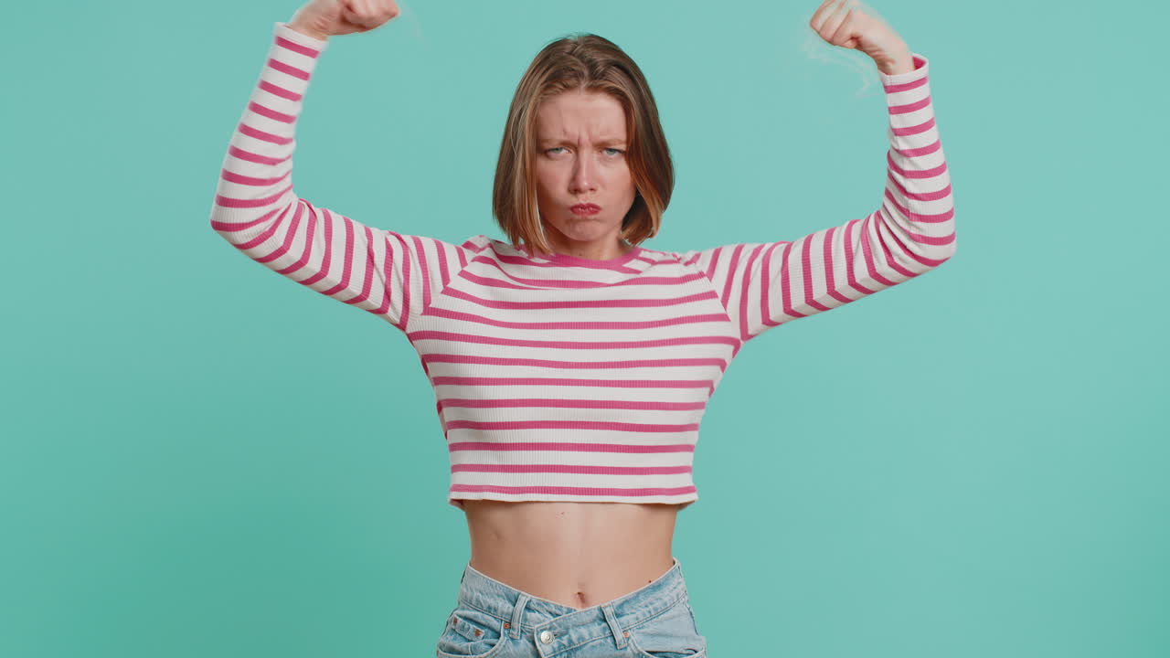 Woman showing biceps and looking confident feeling power strength to fight for rights success win