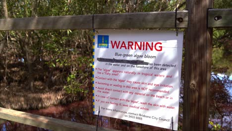 Warning-sign-display-by-the-Brisbane-city-council,-provide-the-information-about-the-blue-green-algae-bloom-in-dry-season-and-detection-of-halobacterium-salinarum-in-the-water-in-Boondall-Wetlands